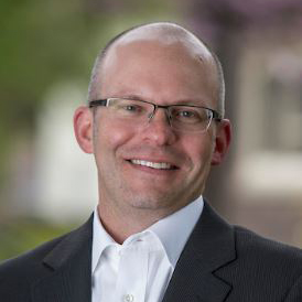 Profile picture of Mark Peltz in a suit in front of a blurred outdoor location